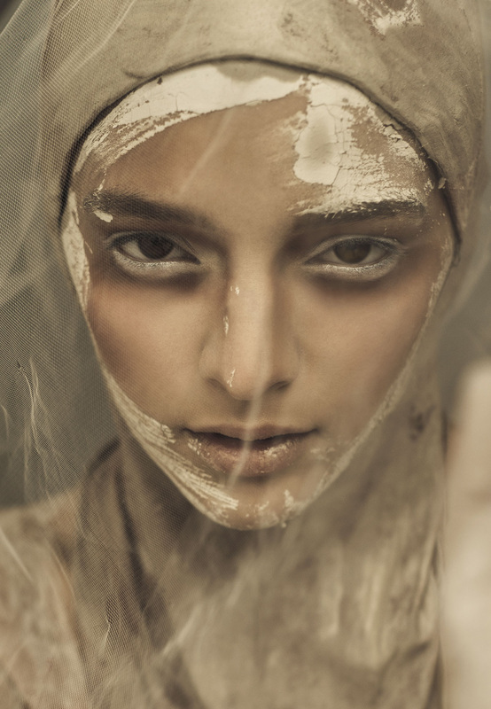 Female model under veil and covered with wet clay and makeup by Nika Vaughan
