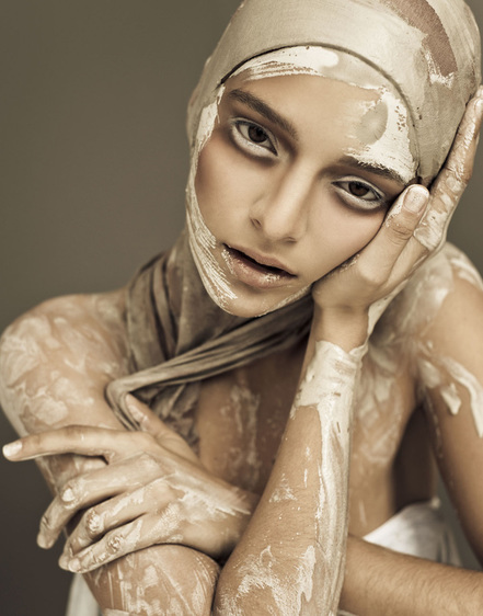 Female model covered in wet clay and makeup by Nika Vaughan